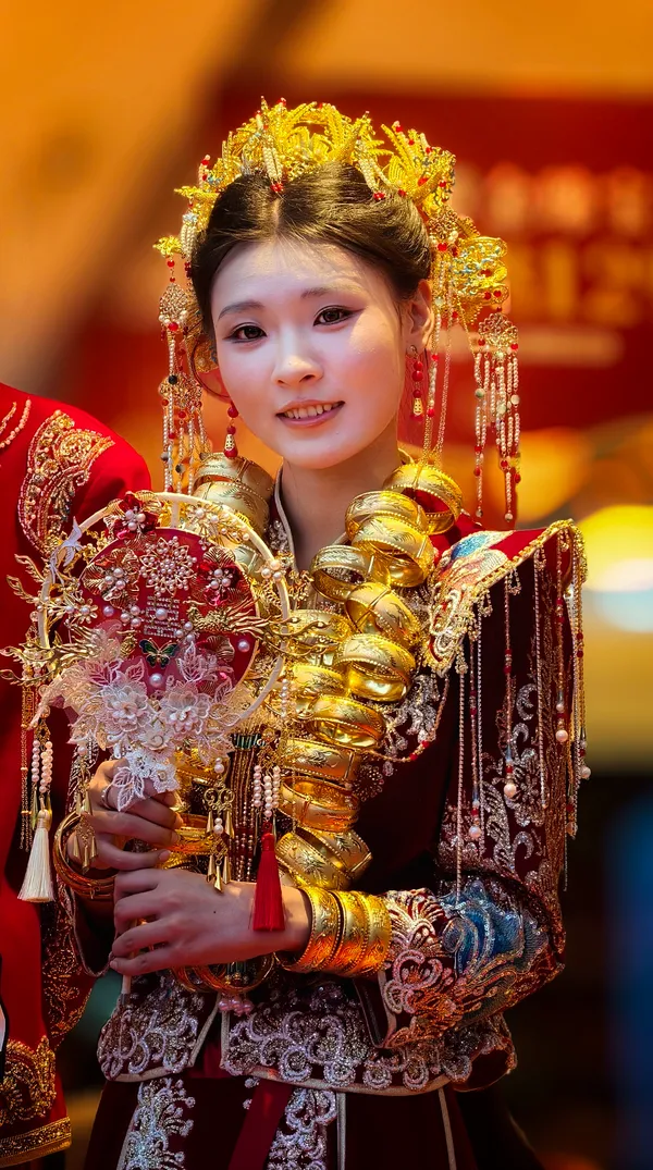 Chinesische Braut in rot-goldener Hochzeitskleidung